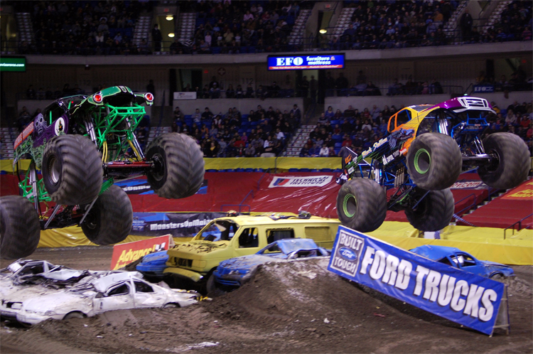 Monster Trucks Black Stallion and Grave Digger battle it out in front of a 