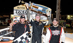 Austin Hill hoists the massive Kevin Whitaker Chevrolet 140 race winner trophy over his head in victory lane at the ½ mile semi-banked oval of Greenville Pickens Speedway in South Carolina