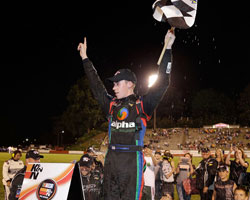 Ben Rhodes stands atop the Alpha Energy Solutions Chevrolet Impala waving the checkered flag after his victory at Bowman Gray Stadium in North Carolina