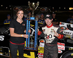 A K&N representative poses with the NAPA Auto Parts/Toyota 150 race winner Chris Eggleston and the NASCAR K&N Pro Series West first place trophy
