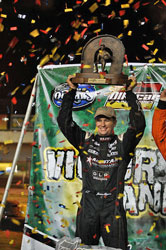 Driver Jason Meyers hoisting a 1st place trophy in Victory Lane.