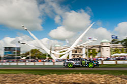 No Downton Abbey here. JR powers past the stately Goodwood Manor House and the massive display of this year’s event sponsor

