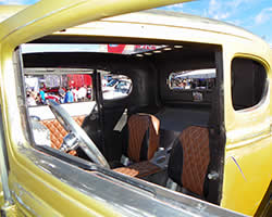 Custom upholstery, custom sheet metal interior, and the beautiful black and Scion Xb gold patina paint scheme of the Hogie Shine Rat Rod.