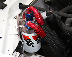 A CV Products remote oil filter adaptor is used to relocate K&N Wrench-Off Oil Filter number HP-1018 on the Ford Racing Mustang RTR