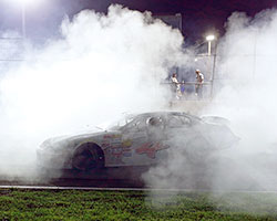 Sergio Pena celebrates his NASCAR K&N Pro Series East race win at Columbus Motor Speedway with a triumphant cloud of white smoke