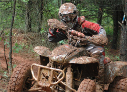 Angela Horn goes through mud, over rocks and does not stop in the pit area during quad races in her Honda 400EX, photo by Stacie Siegers