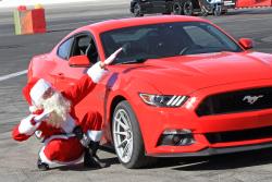 Santa posing with his 2017 Ford Mustang 5.0L at Orange show speedway