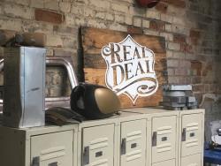 REAL DEAL signage propped on cabinets in shop
