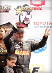 Greg Adler on the podium after racing his Pro4 race truck in the Lucas Oil Off Road Racing Series