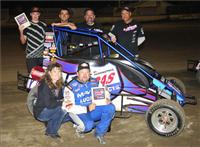 Cory Kruseman and his crew crowd around his midget car after a victory at the VRA.