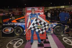 Ryan Partridge shows the checkered flag after winning the NASCAR K&N Pro Series West race