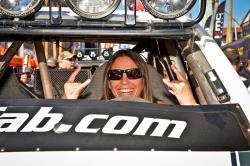Photo of Nicole smiling and behind the wheel of her race truck