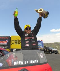 NHRA Pro Stock driver Drew Skillman holding up his trophy at Route 66 Raceway in Chicago, Illinois