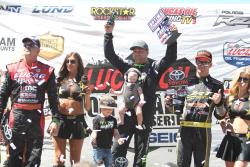 K&N Filters-sponsored driver Kyle LeDuc on top of the podium with his kid after his strong win