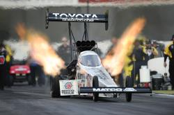 Antron Brown's Top Fuel racer exhales fire as it competes in 2017 Mello Yello Drag Racing event.